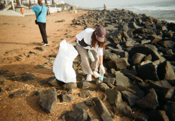 Woman picking up ocean plastic